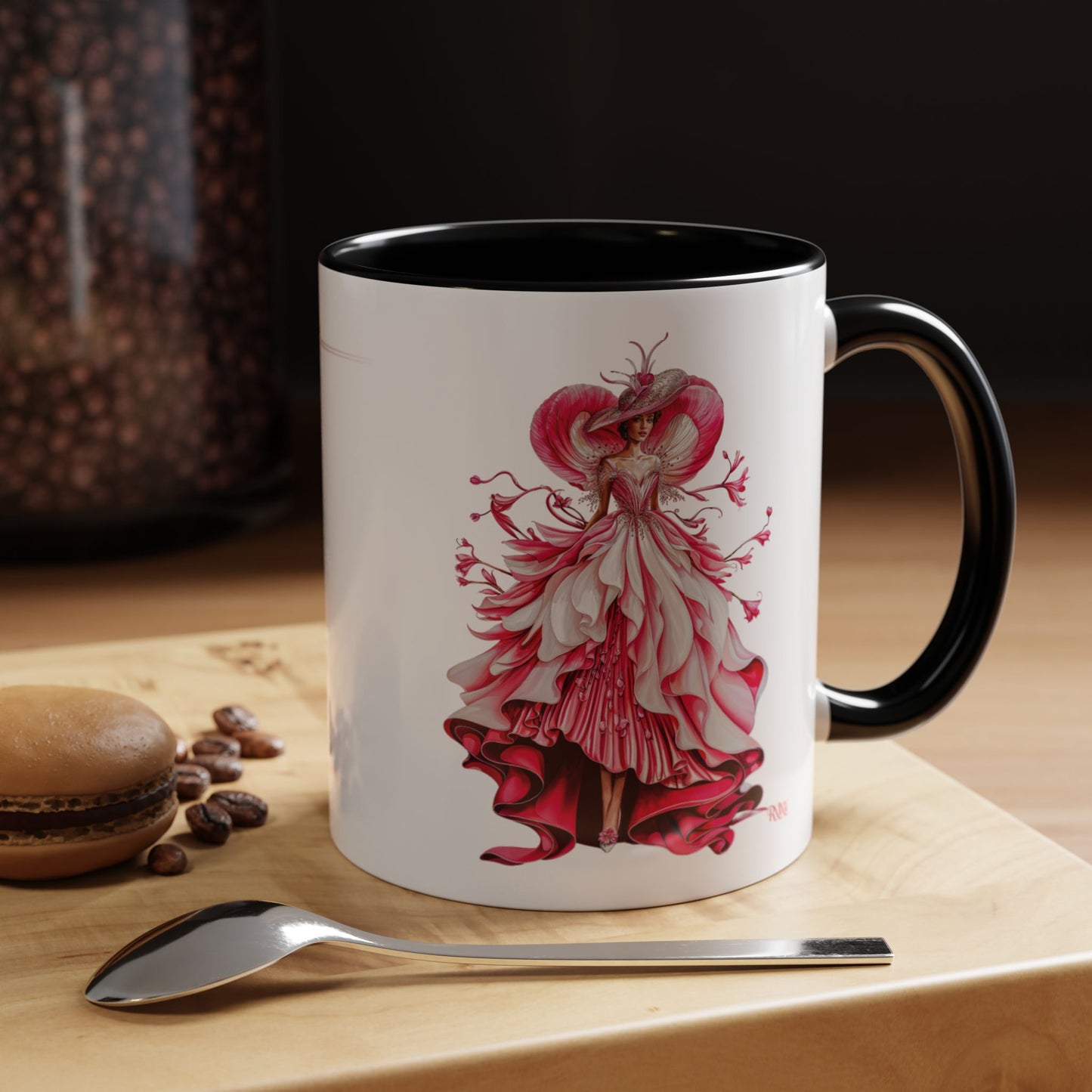 Mug with a red and white dress design on a wooden surface with coffee beans and a spoon.