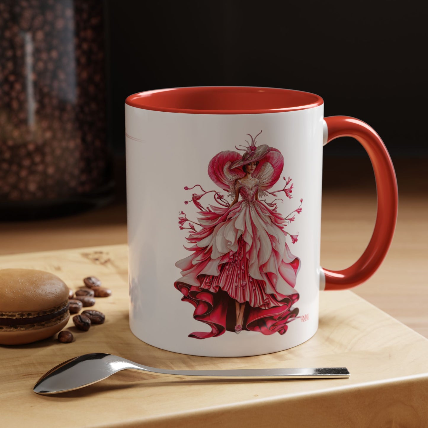 Mug with a red and white dress design on a wooden surface with coffee beans and a spoon.