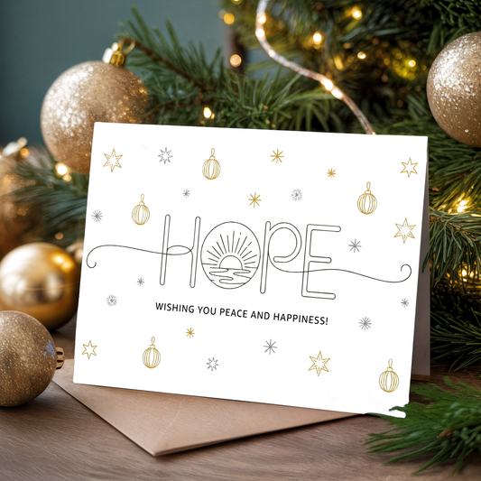 Christmas card with "HOPE" and festive decorations on a wooden surface.