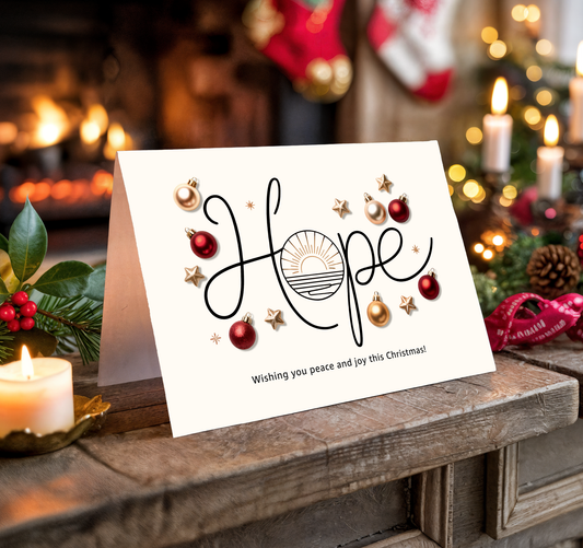 Christmas card with "Hope" and festive decorations on a wooden surface with candles and stockings.