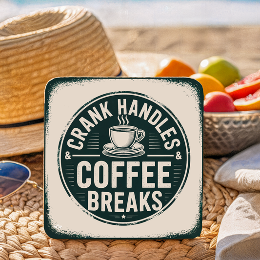 Coaster with "Crank Handles & Coffee Breaks" text on a picnic setting