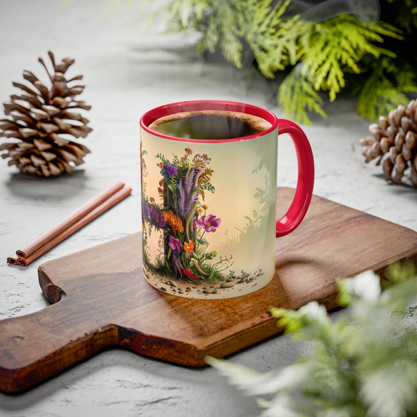 Mug with floral design on a wooden board with cinnamon sticks and pine cones.