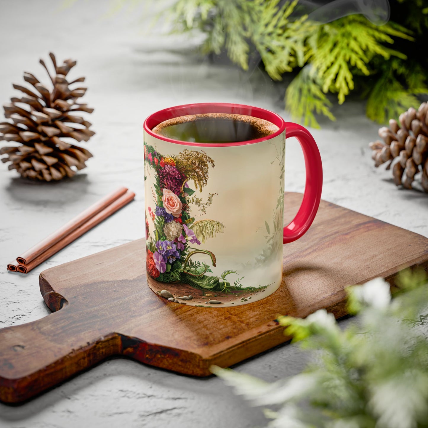 Mug with floral design on a wooden board with cinnamon sticks and pine cones.