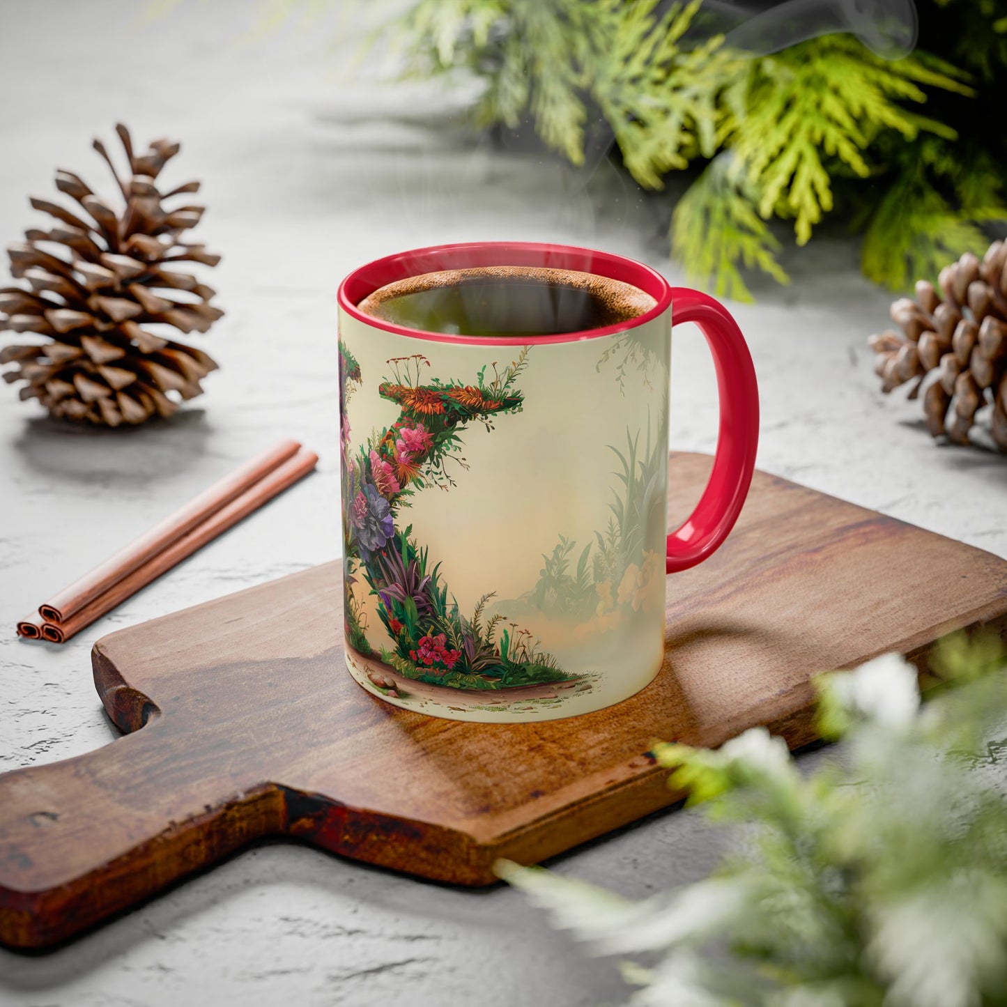 Decorative mug with a floral design on a wooden board with pine cones and cinnamon sticks.