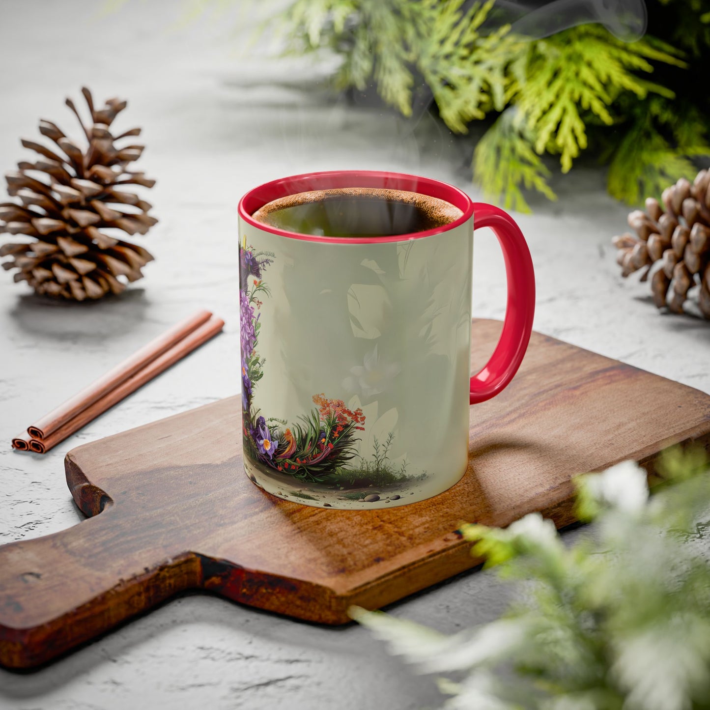 Mug with floral design on a wooden board with pine cones and cinnamon sticks.
