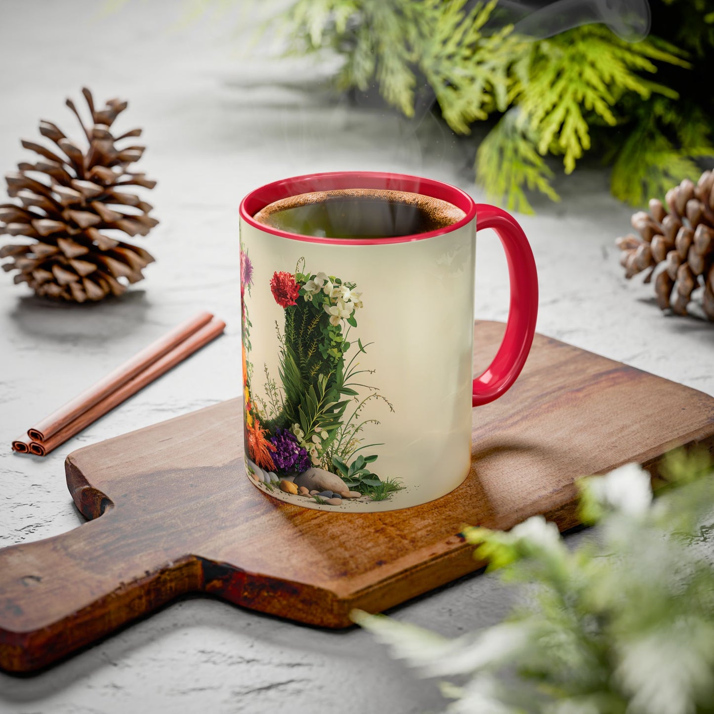 Mug with floral design on a wooden board with pine cones and cinnamon sticks.