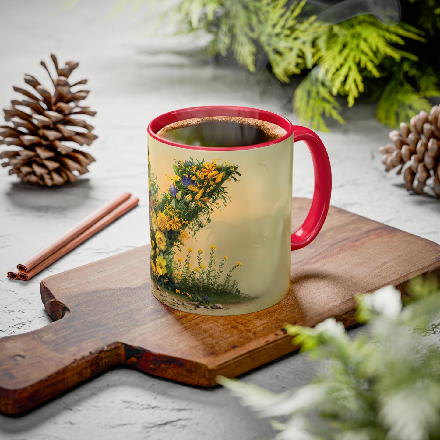 Mug with floral design on a wooden board with pine cones and cinnamon sticks.