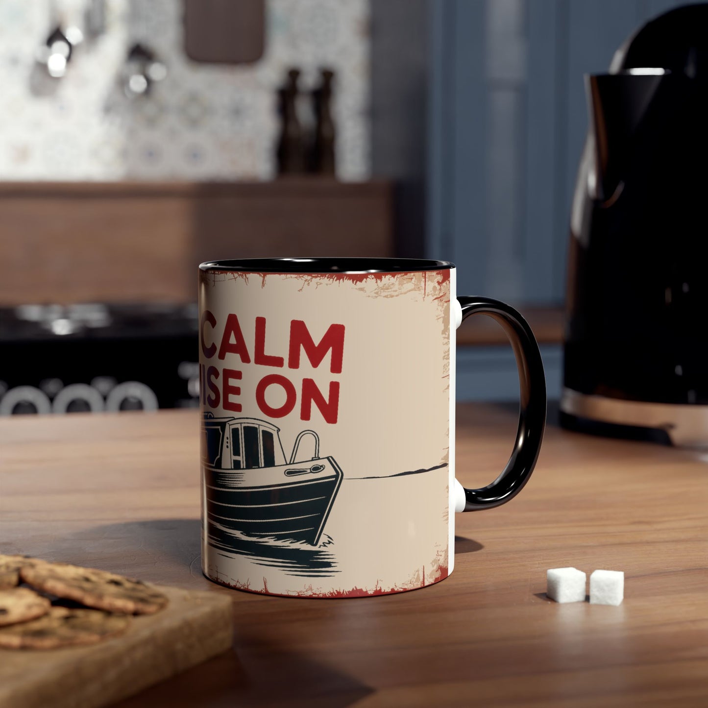 Mug with text and boat graphic on a kitchen counter.
