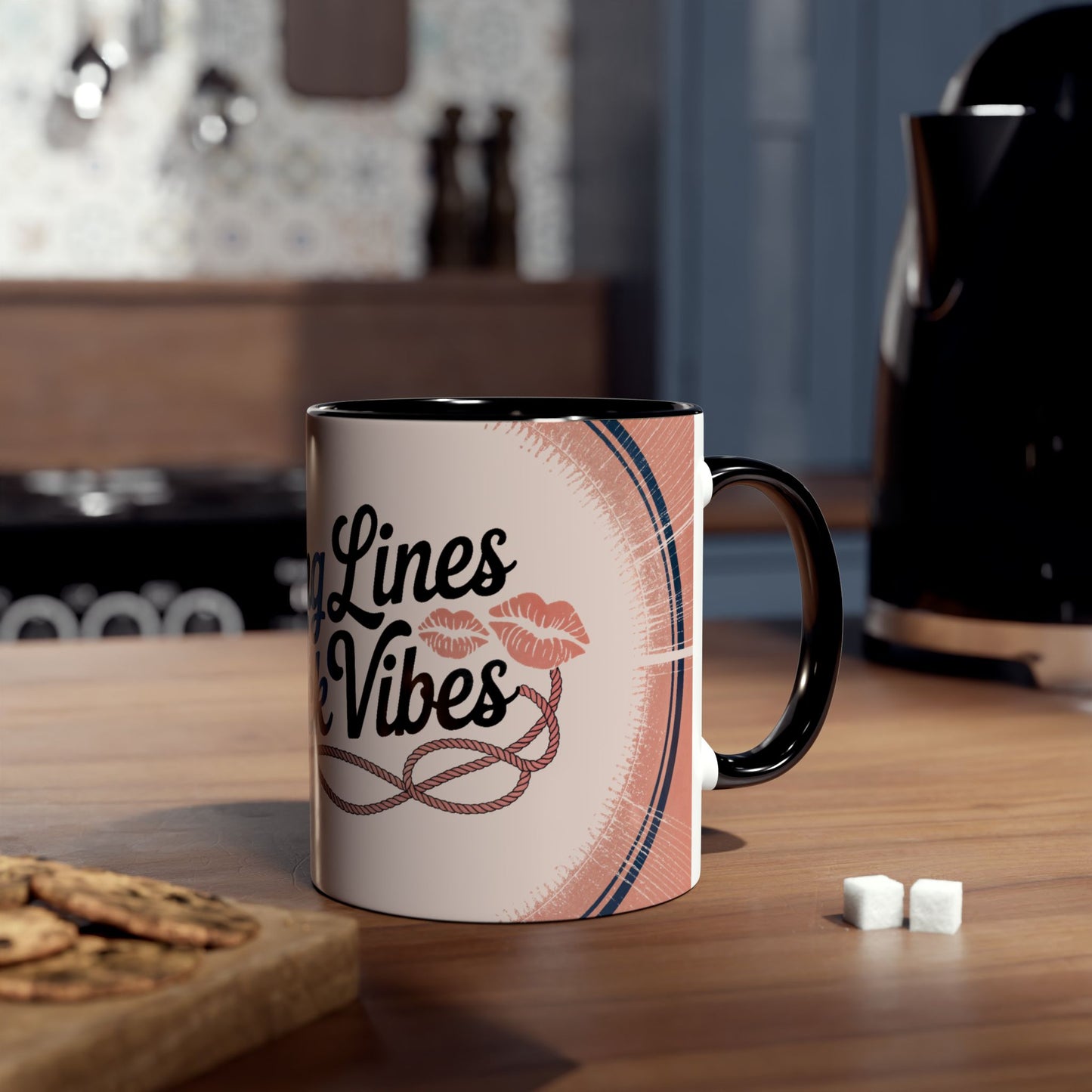 Mug with lipstick design on a kitchen counter with cookies and sugar cubes.