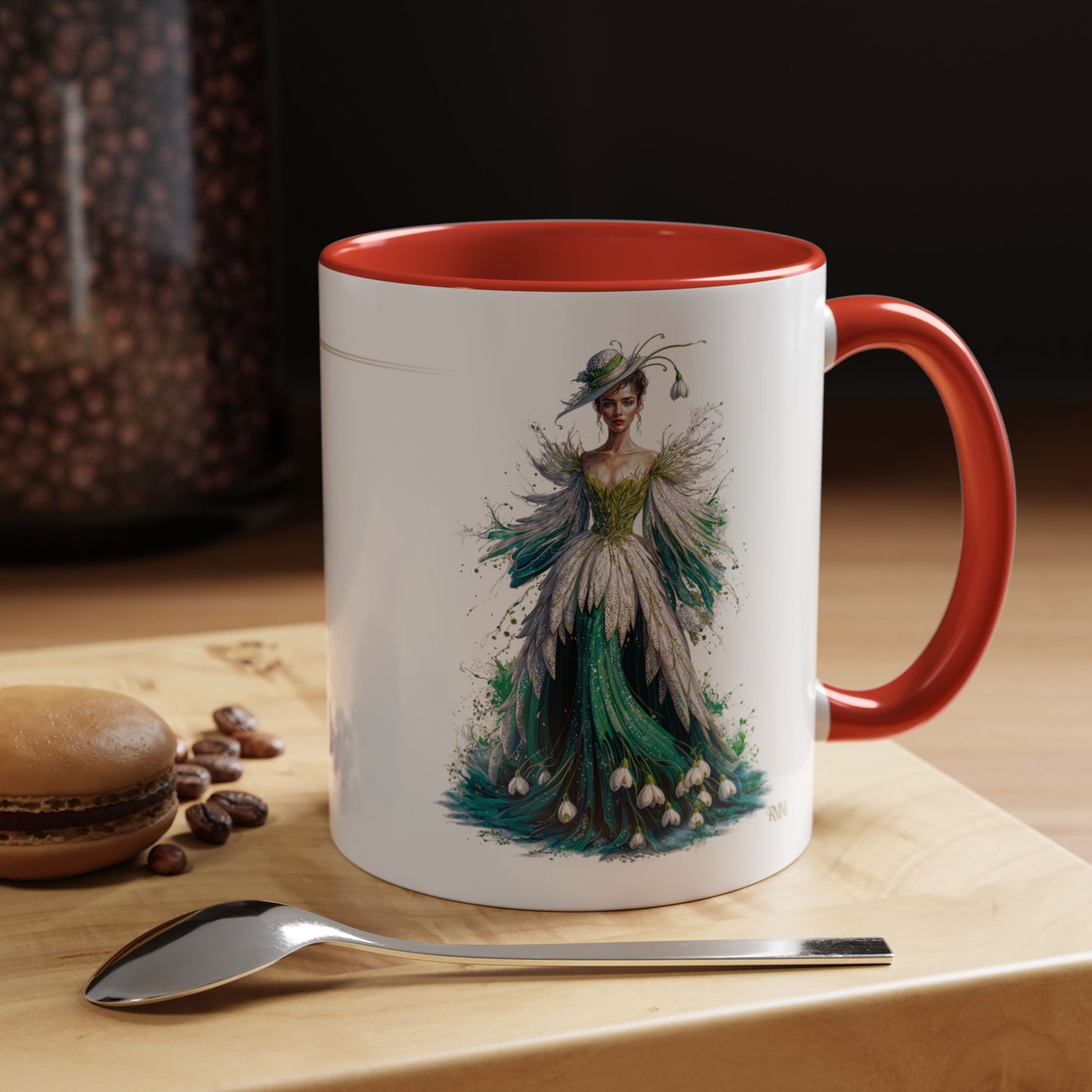Mug with a decorative design of a woman in a gown on a wooden surface with coffee beans and a spoon.
