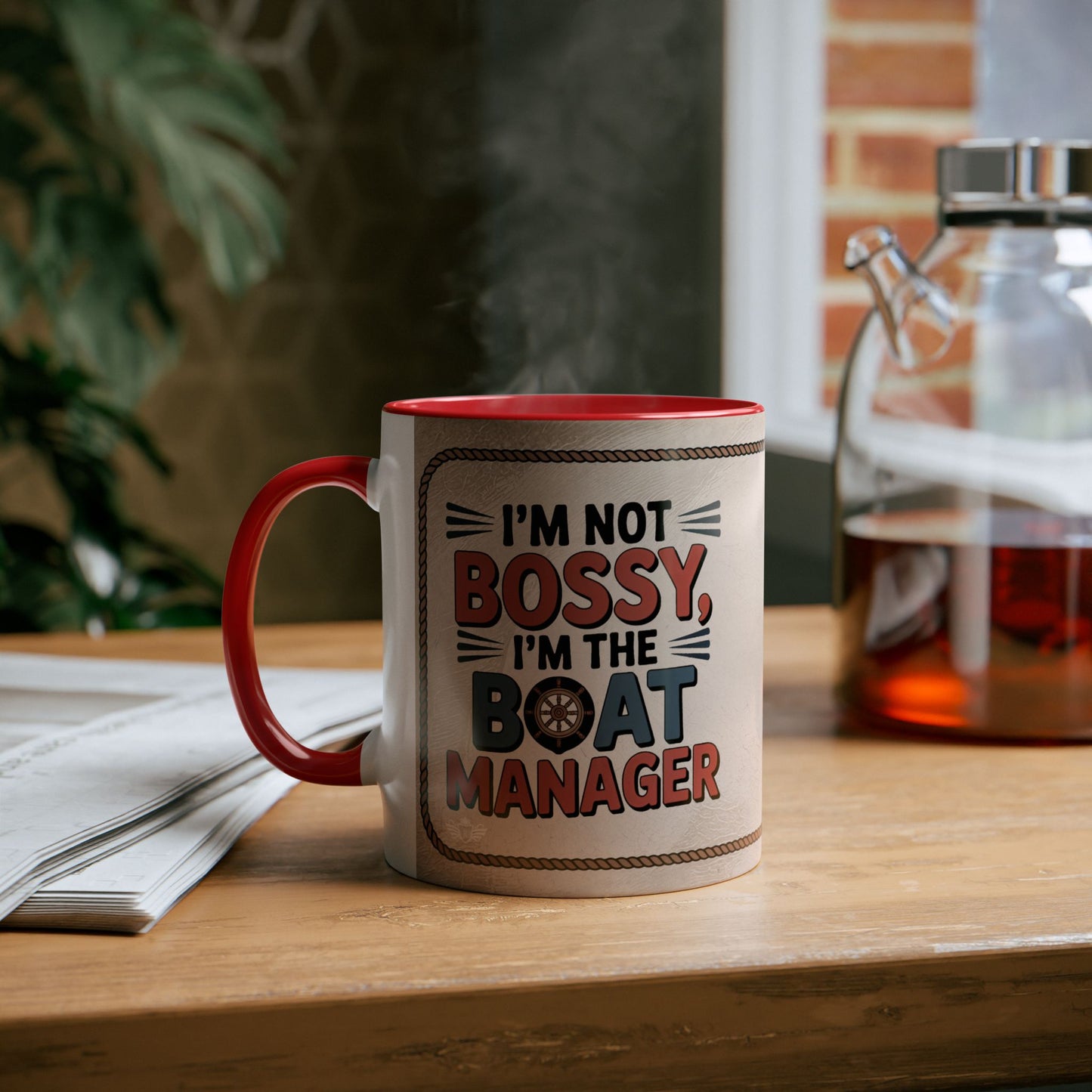 Mug with "I'm not bossy, I'm the boat manager" text on a wooden table.