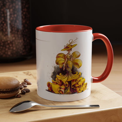 Mug with a colorful design of a woman in a yellow dress on a wooden surface with coffee beans and a spoon.