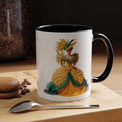 Mug with a decorative design of a woman in a yellow dress on a wooden surface with coffee beans and a spoon.