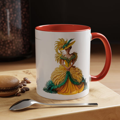 Mug with a decorative design of a woman in a yellow dress on a wooden surface with coffee beans and a spoon.