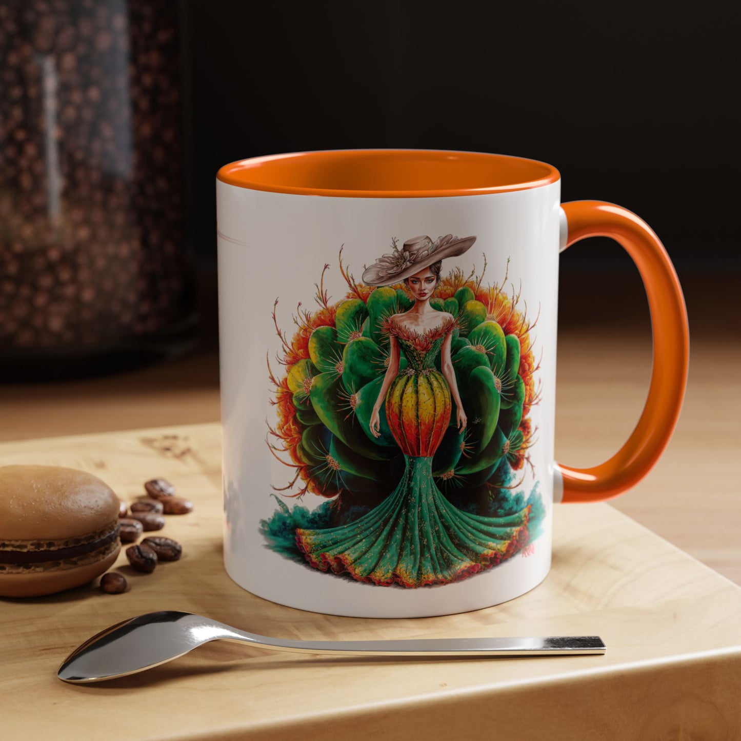 Mug with a colorful design of a woman and cactus on a wooden surface with coffee beans and a spoon.