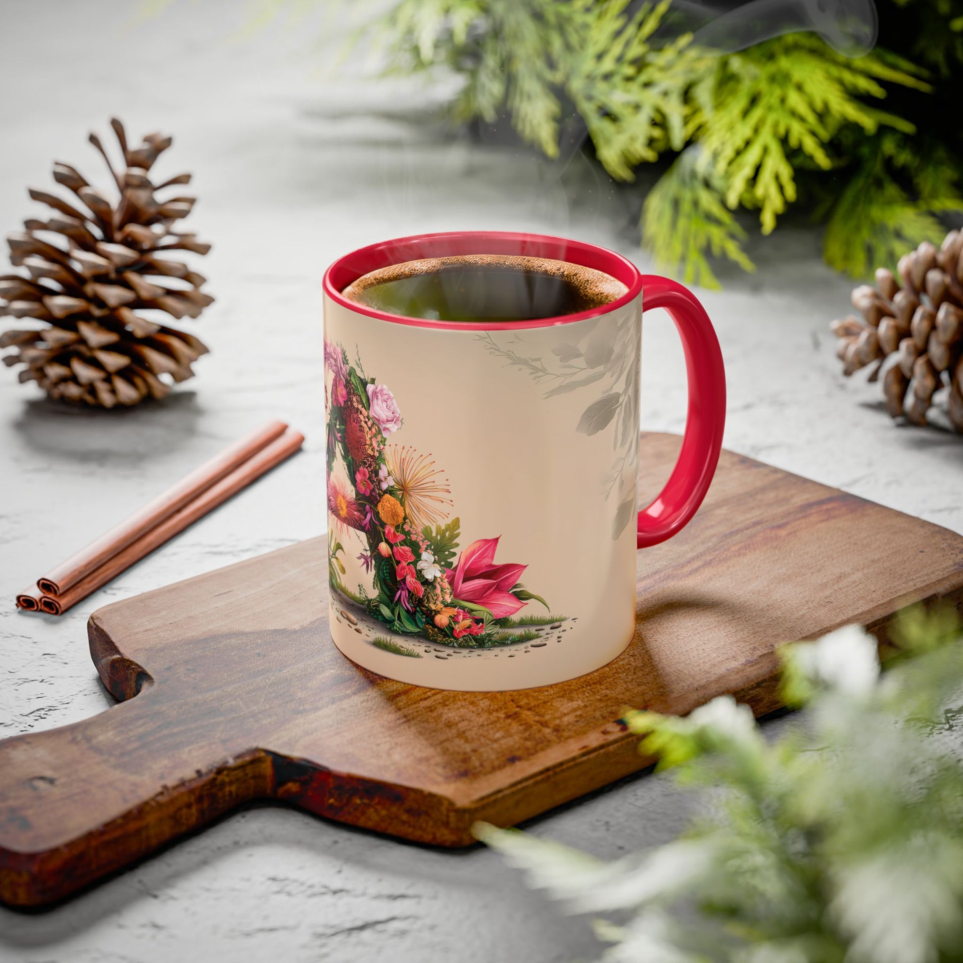Mug with floral design on a wooden board with cinnamon sticks and pine cones.