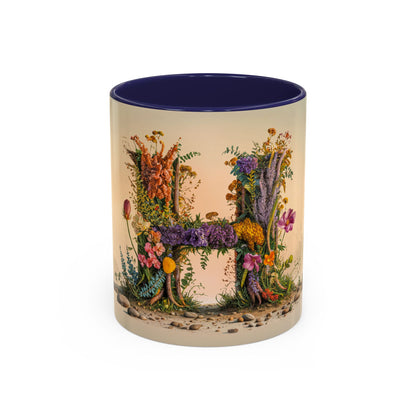 Mug with floral design spelling 'H' on a beige background