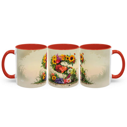 Three ceramic mugs with floral designs and red handles on a white background