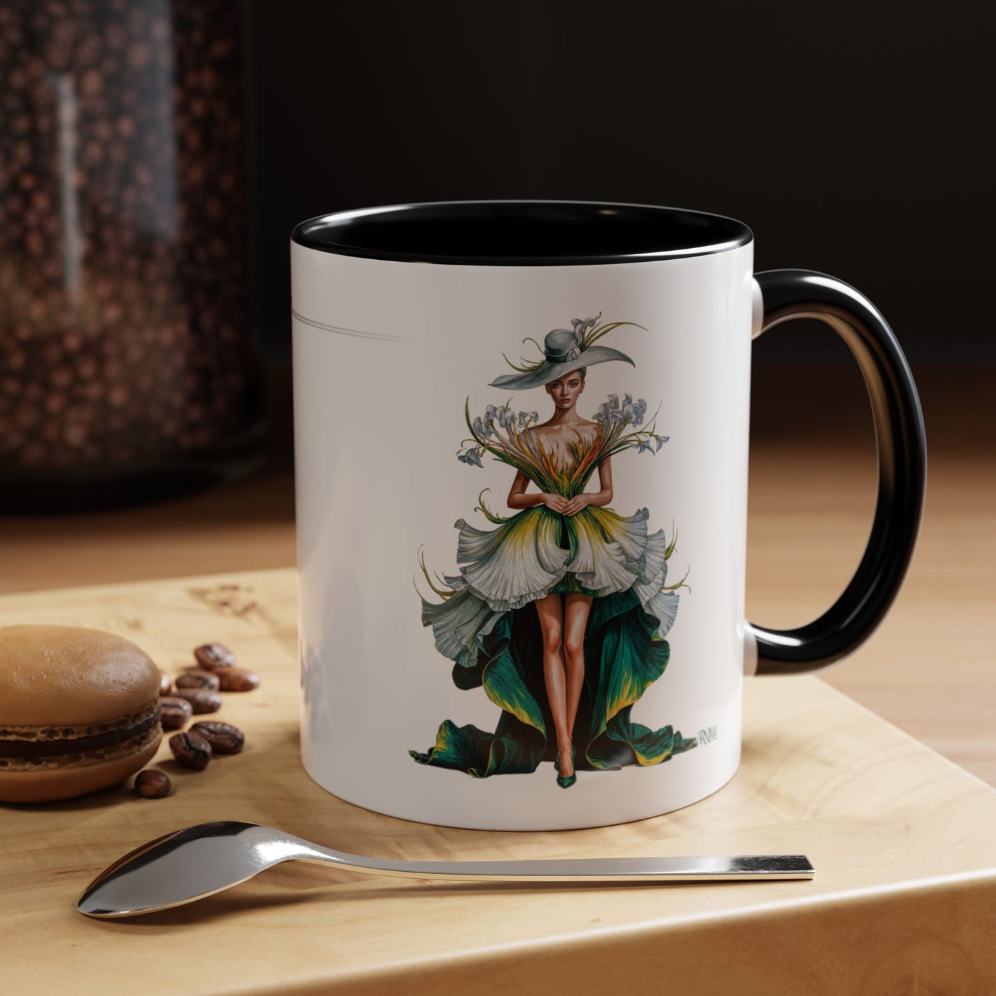 Mug with a decorative design of a woman holding flowers on a wooden surface with coffee beans and a spoon.