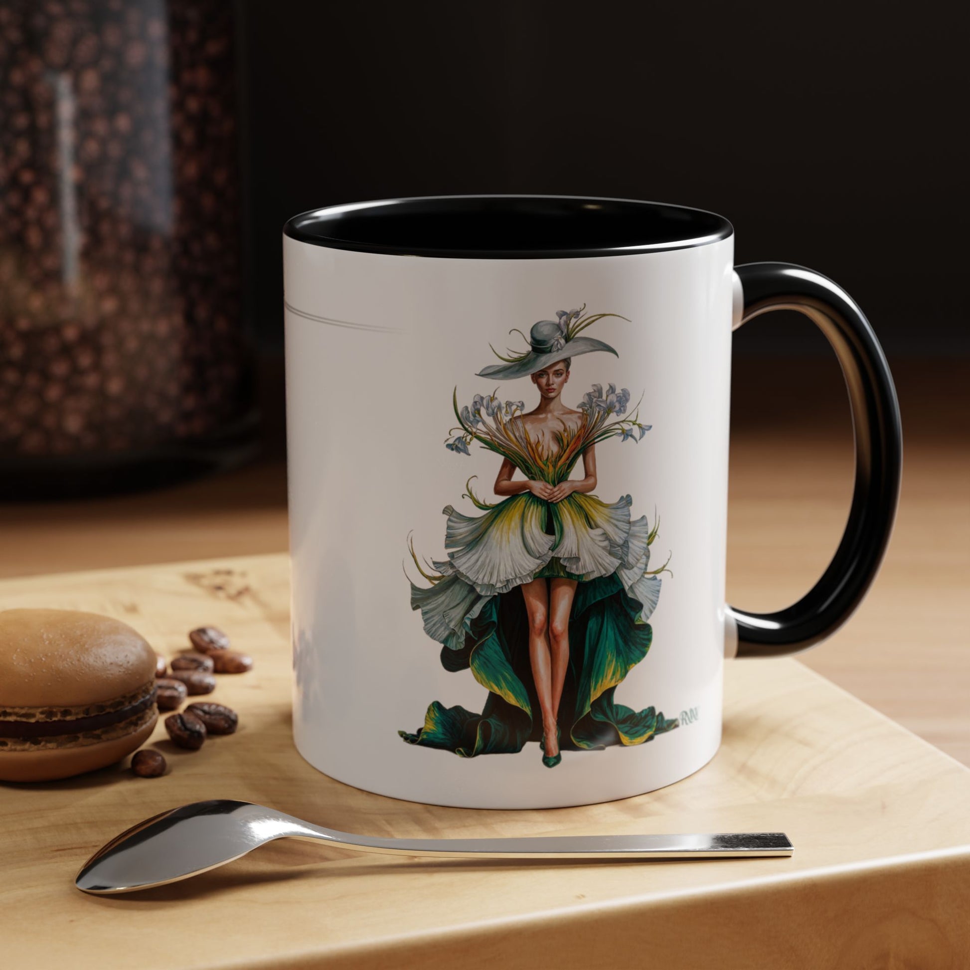 Mug with a decorative design of a woman holding flowers on a wooden surface with coffee beans and a spoon.