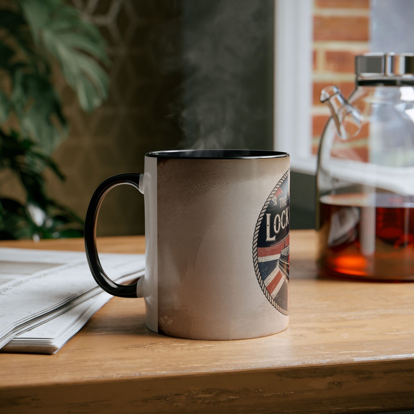Mug with a boat on a wooden surface next to a newspaper and a glass container.